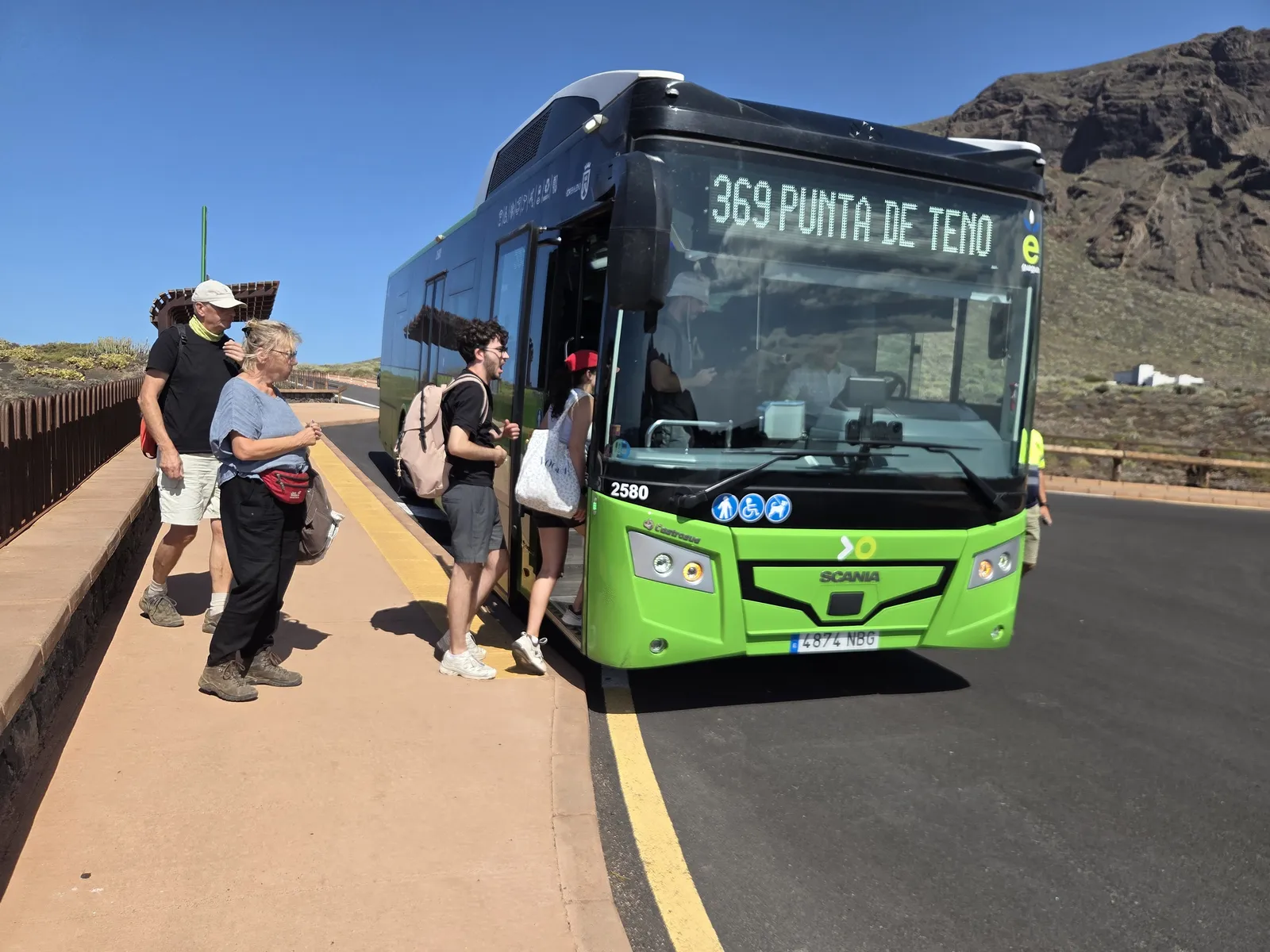 Guagua verde de TITSA de la línea 369 Punta de Teno con viajeros junto a la parada